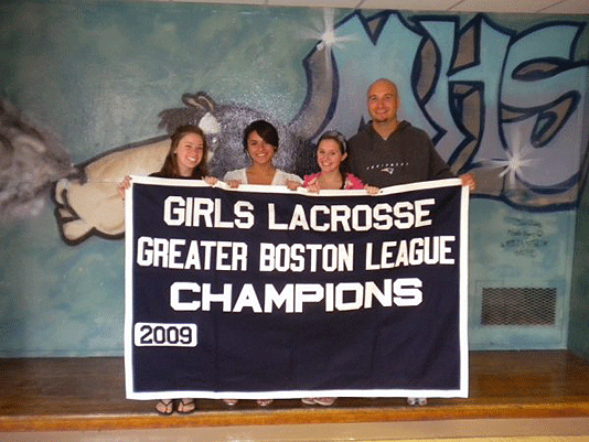 Girls lacrosse captains and coach with championship banner