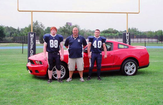 MHS football coach and captains with Ford Mustang
